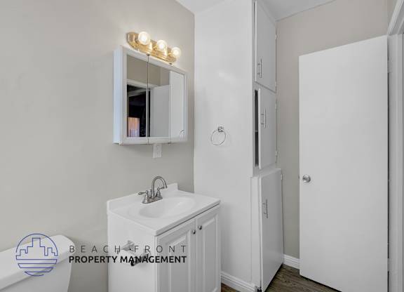 A white bathroom with a sink, mirror, and medicine cabinet.