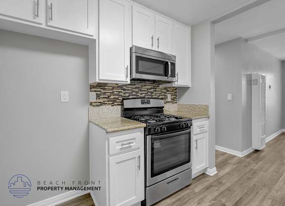 A kitchen with a stove, microwave, and cabinets.