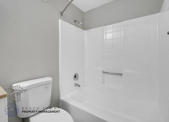 A white bathroom with a walk-in shower and a toilet.