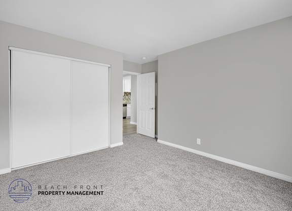 A room with a carpeted floor and a sliding door.