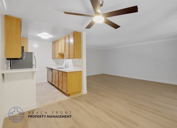A spacious room with wooden flooring and a ceiling fan.
