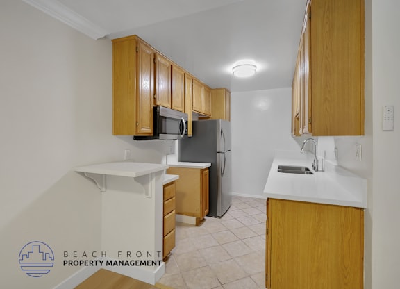 A kitchen with wooden cabinets and a refrigerator.