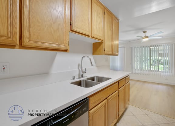 A kitchen with wooden cabinets and a black dishwasher.