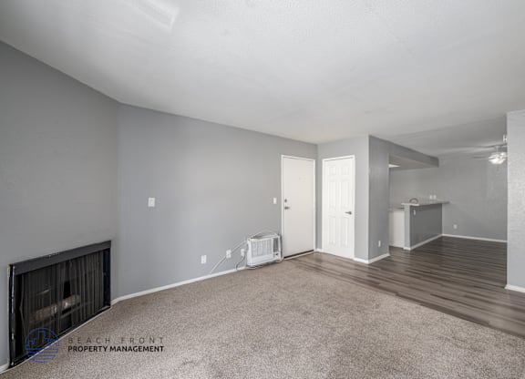 A spacious room with a fireplace and a carpeted floor.