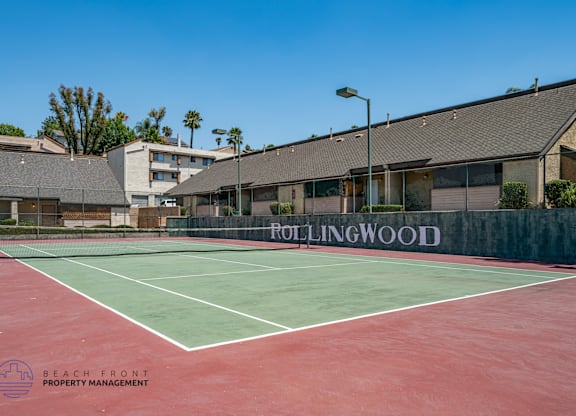 A tennis court with the name Rollingwood on the wall.