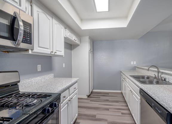 A kitchen with a stove, microwave, and oven.