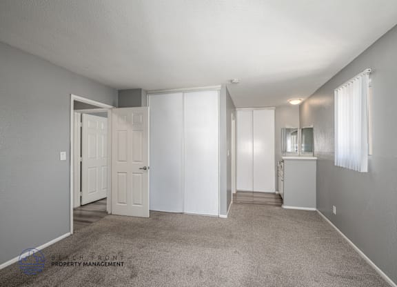 A spacious room with a carpeted floor and white walls.