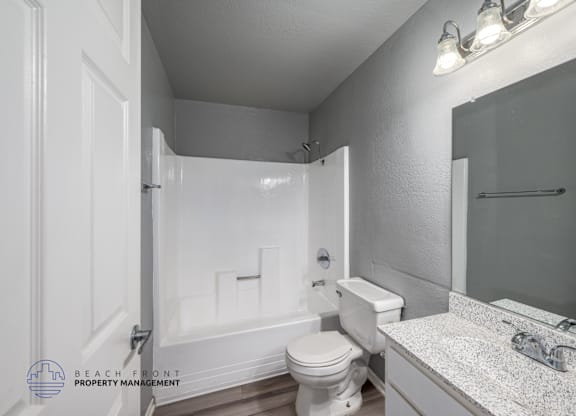 A bathroom with a toilet, sink, and bathtub.