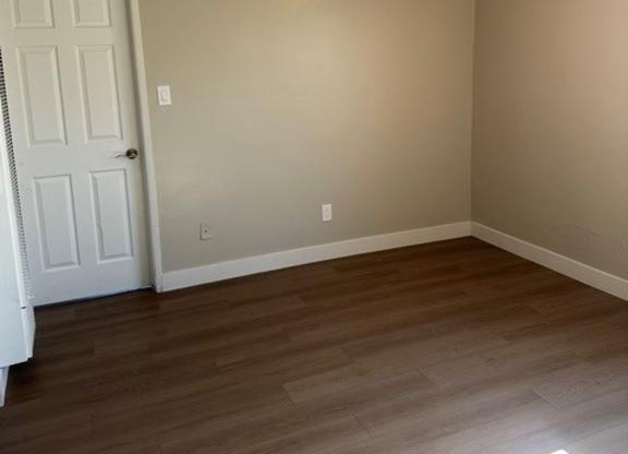 A room with a ceiling fan and a door.