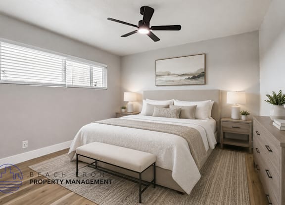 A well-lit bedroom with a large bed, a bench, and a ceiling fan.