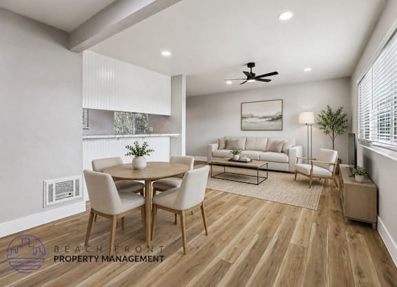 A well-lit, modern dining room with a wooden floor and a white ceiling fan.