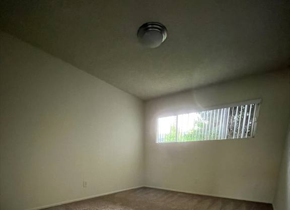 an empty room with carpet and a window