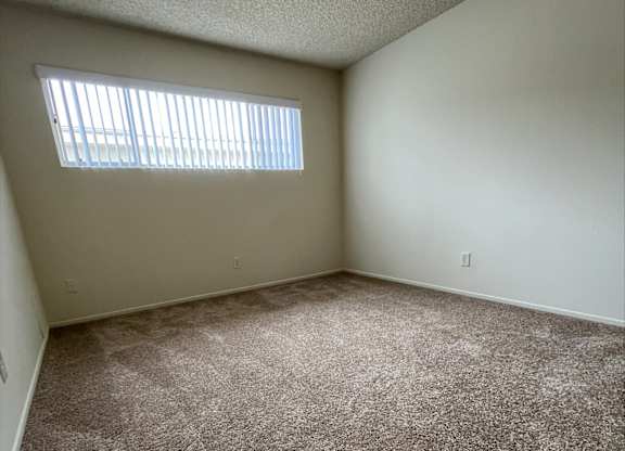 an empty room with carpet and a window
