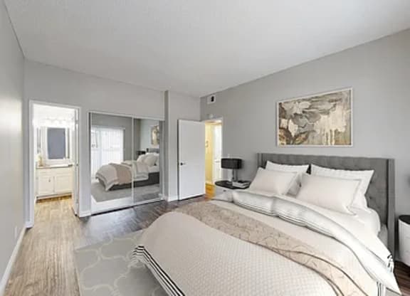 A bedroom with a large bed and a painting on the wall.