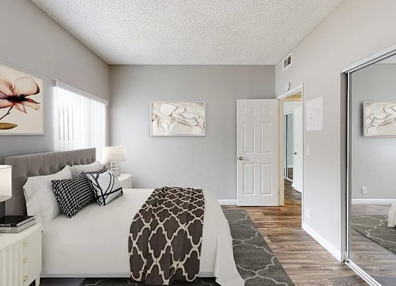 A bedroom with a bed, nightstand, and two framed pictures on the wall.