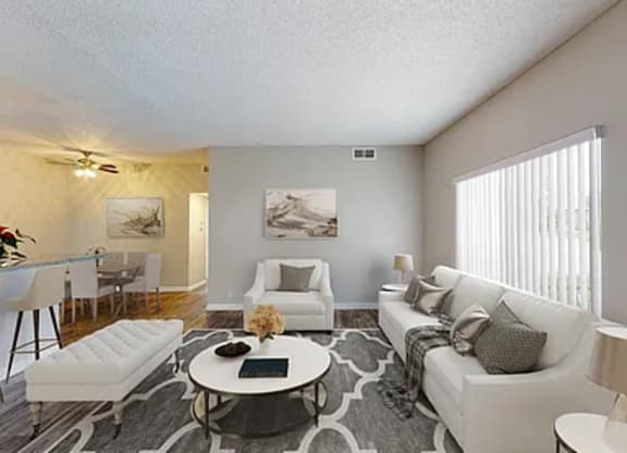 A living room with a white couch, a coffee table, and a rug.