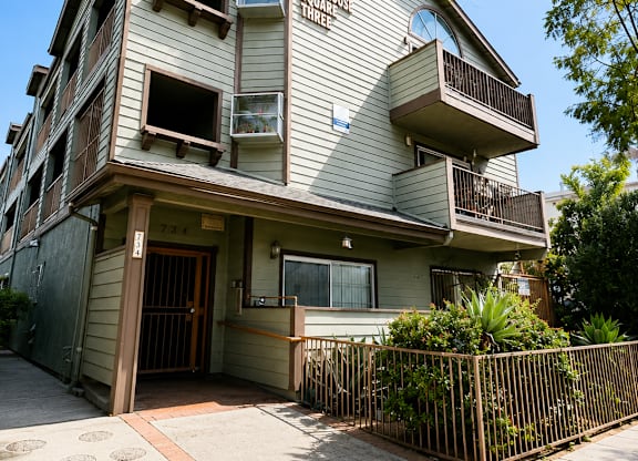 A two-story building with a balcony and a gate.