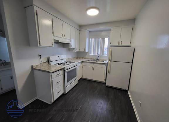 A kitchen with white appliances and cabinets.
