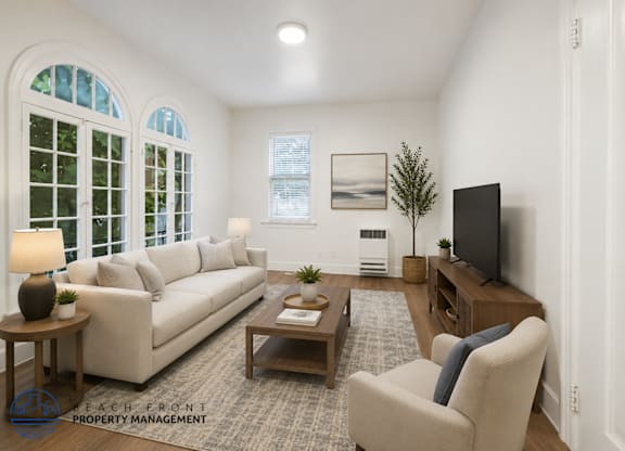 A living room with a couch, chair, and television.