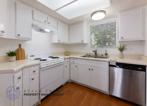 A kitchen with white cabinets and a stainless steel dishwasher.