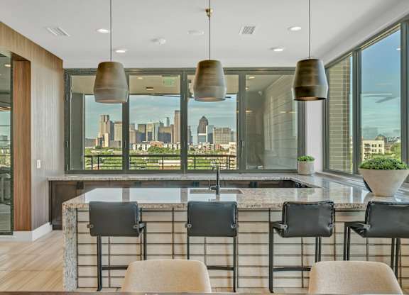 A modern kitchen with a marble countertop and a view of the city.
