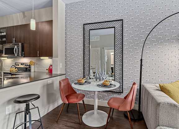 A modern kitchen with a dining table and chairs.