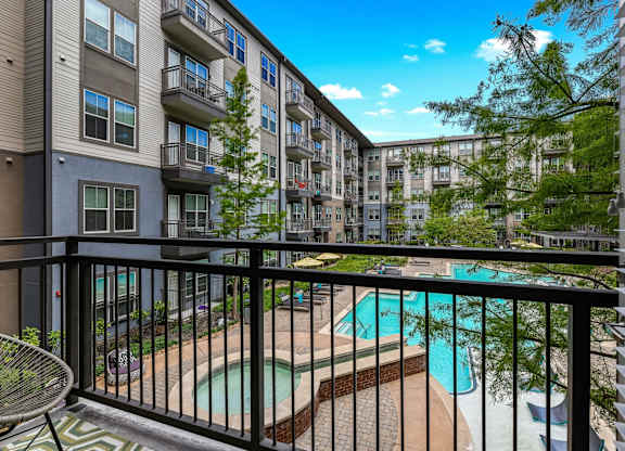 A balcony with a pool and a chair.