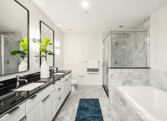 A bathroom with a marble floor and a white tub.