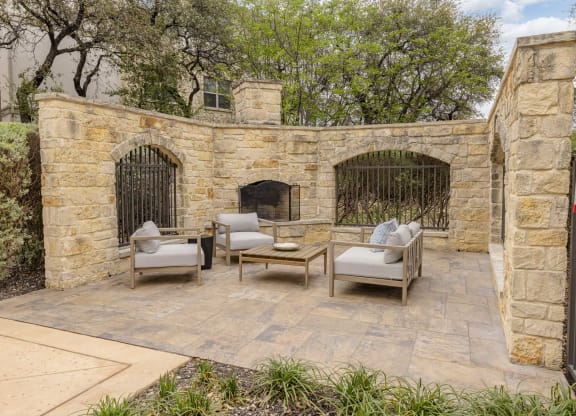 the backyard has a stone wall and a fireplace