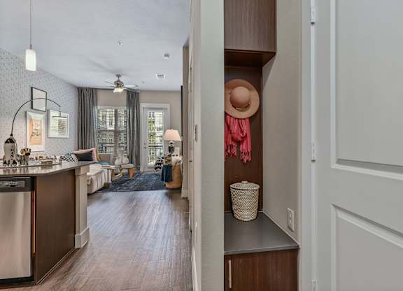 A kitchen with a washing machine and a hat on a hook.