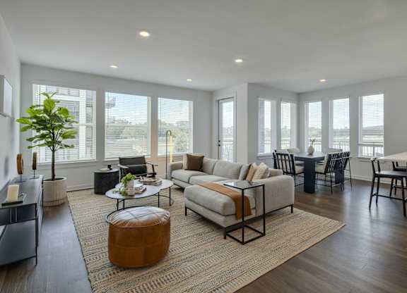 a living room with a couch and a table in front of a window