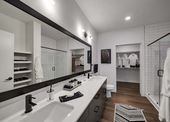 a bathroom with two sinks and a walk in shower in a 555 waverly unit