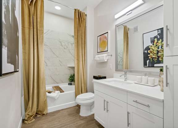 A bathroom with a white toilet, sink, and a marble wall.