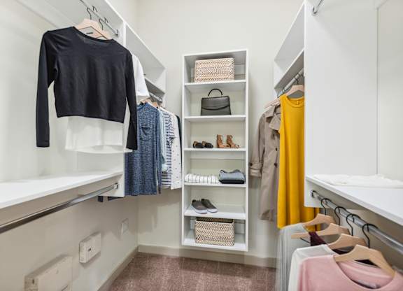 A black shirt hanging on a white closet rod.