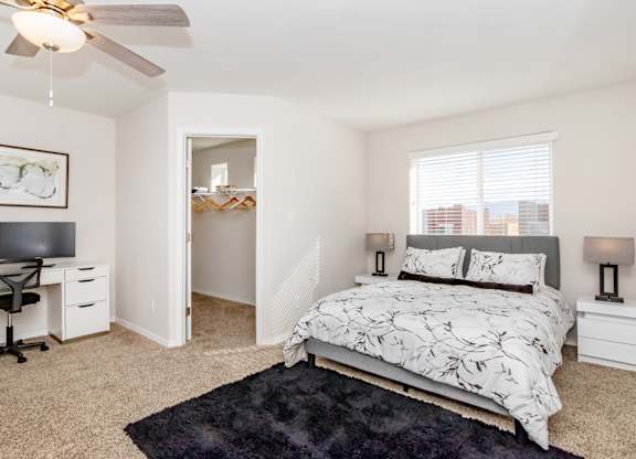 A bedroom with a bed, desk, and chair.