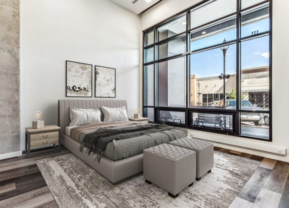 a bedroom with a bed and a large window