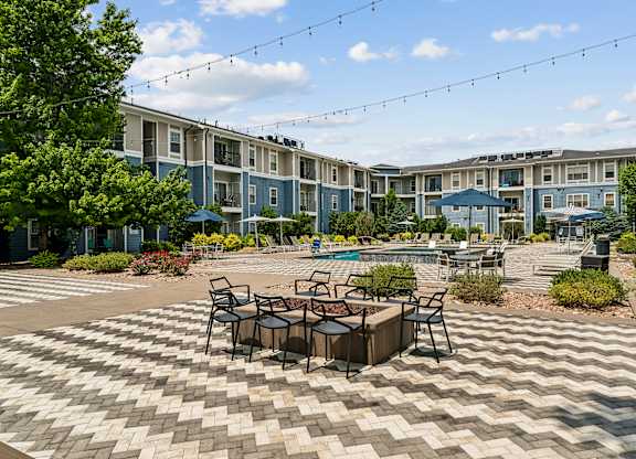 A patio with a table and chairs is in front of a building.