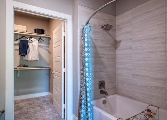 A bathroom with a white tub and a shower curtain.