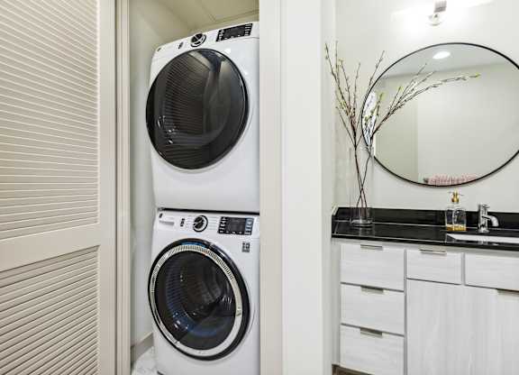 A white front loading washing machine in a laundry room.