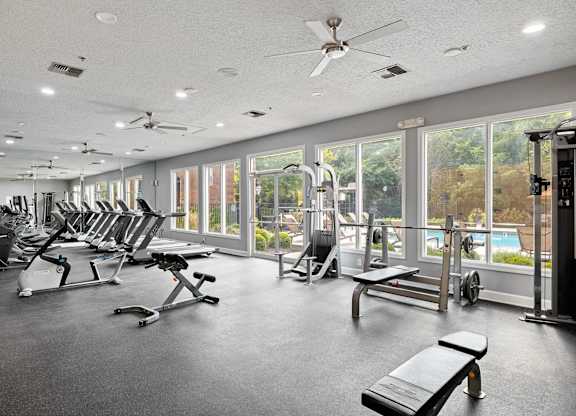 A gym with a variety of equipment including treadmills, weights, and exercise machines.