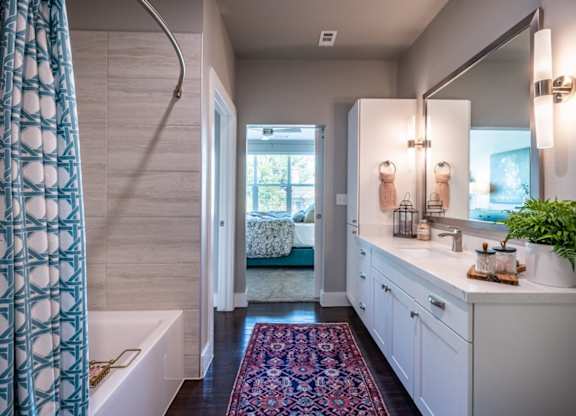 A bathroom with a white tub and a white sink.