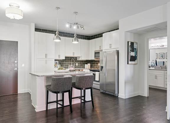 A kitchen with a table and chairs in the middle.