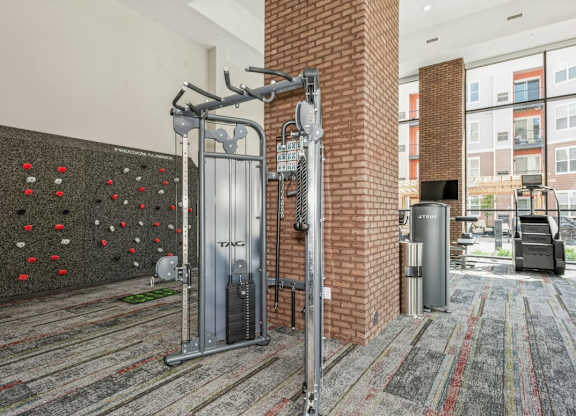A gym room with a climbing wall and a treadmill.