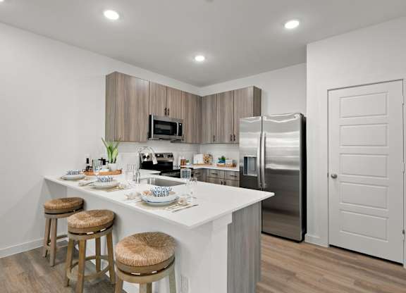 A kitchen with a white countertop and stainless steel appliances.