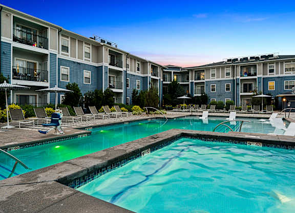 A swimming pool in front of apartment buildings.