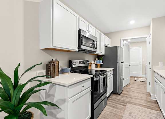 a kitchen with white cabinets and black appliances and a black refrigerator