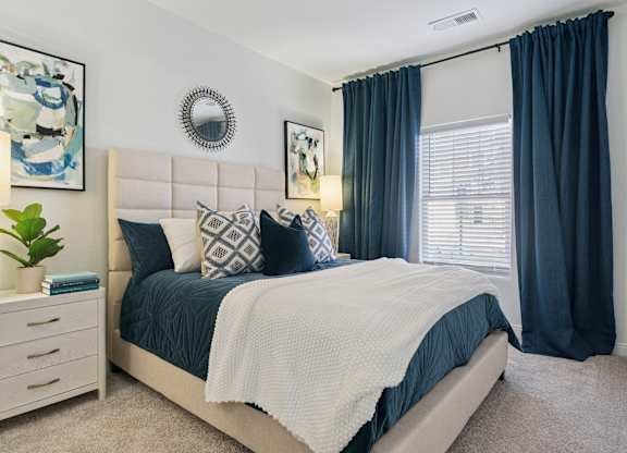 A bedroom with a large bed and a white headboard.