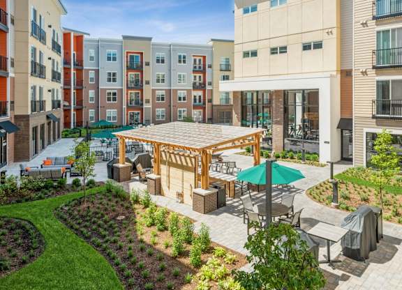 A patio area with a table and chairs is surrounded by apartment buildings.
