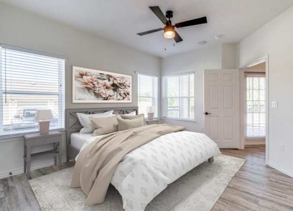 an empty bedroom with a bed and a ceiling fan