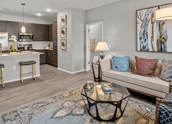 A modern living room with a bar area and a kitchen in the background.